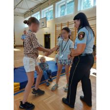 Dziewczynki z funkcjonariuszką ćwiczą samoobronę