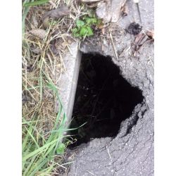 zdjęcie przedstawia głęboką dziurę w asfalcie na ścieżce rowerowej -ul. Osmolicka