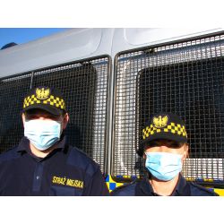 zdjęcie przedstawia strażników miejskich w maseczkach ochronnych
