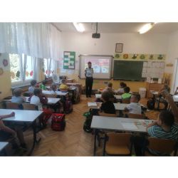 zdjęcie przedstawia klasę z dziećmi oraz strażniczkę miejską prowadzącą zajęcia